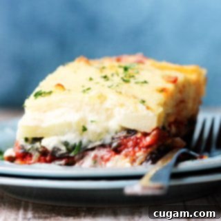 Horizontal shot of a vegetarian moussaka on a blue plate with fork