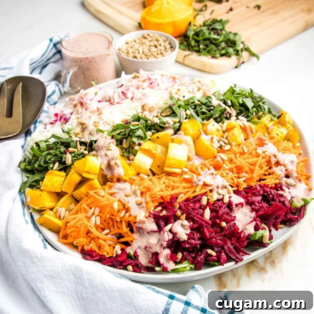 Kaleidoscope Nourish Bowl 9 Vibrant shredded rainbow salad with pink dressing and sunflower seeds on top, ready to be served.