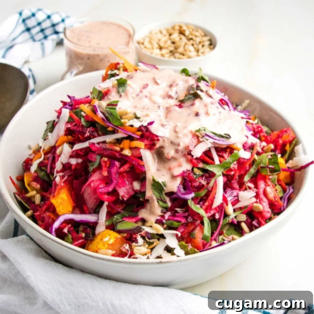 Vibrant tossed colorful salad with pink dressing on top.