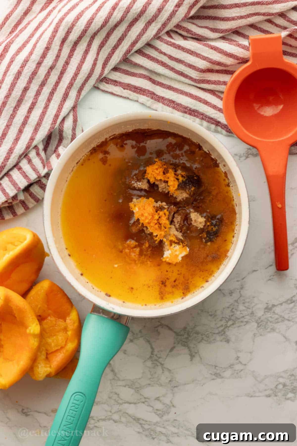 Orange zest, brown sugar, orange juice, and spices combined in a small metal saucepan on a stovetop, ready to be whisked into a glaze.