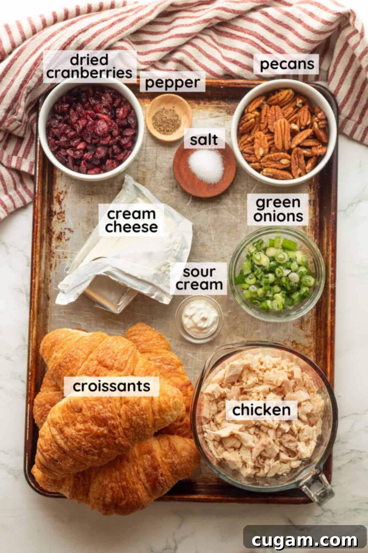 Ingredients for cranberry chicken pecan salad in labeled glass bowls, neatly arranged.