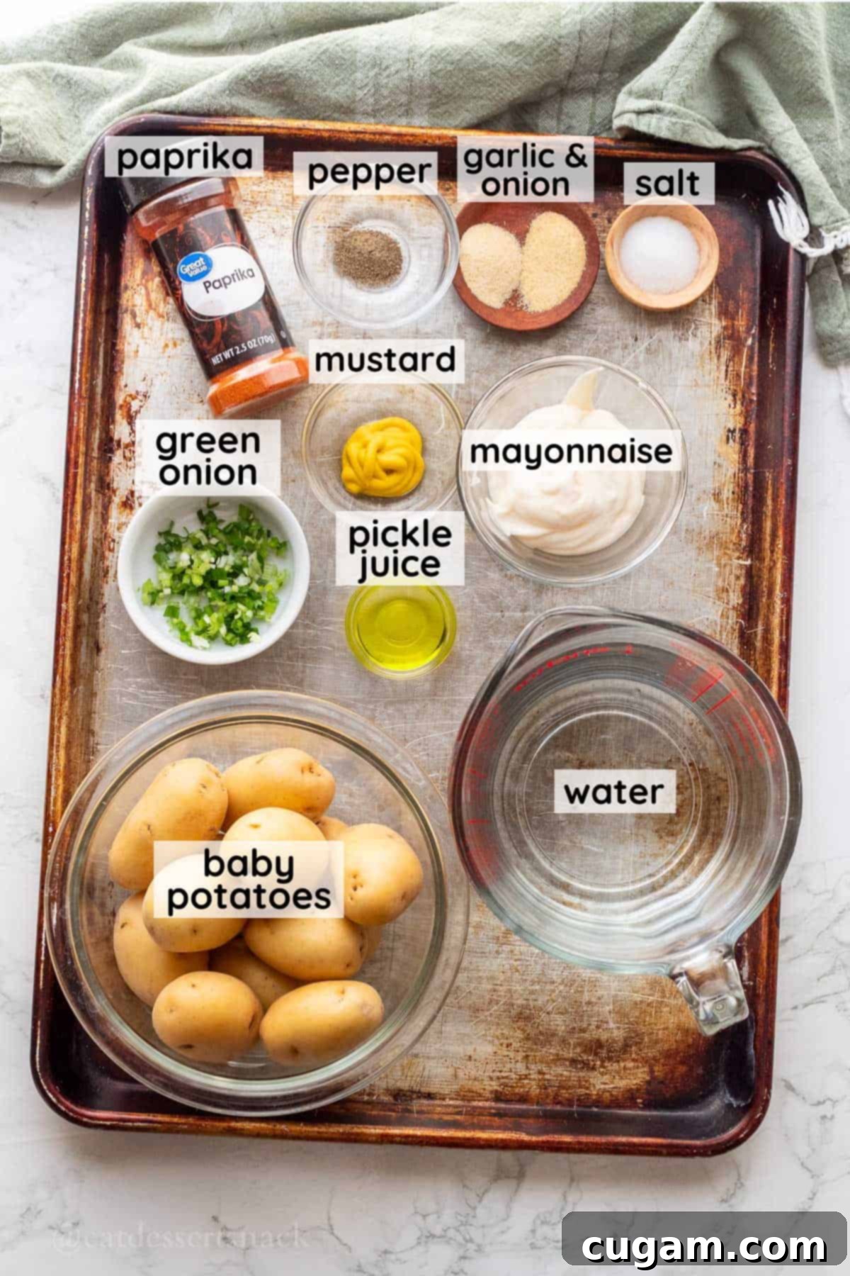 Ingredients for deviled eggs in glass bowls on metal baking sheet.