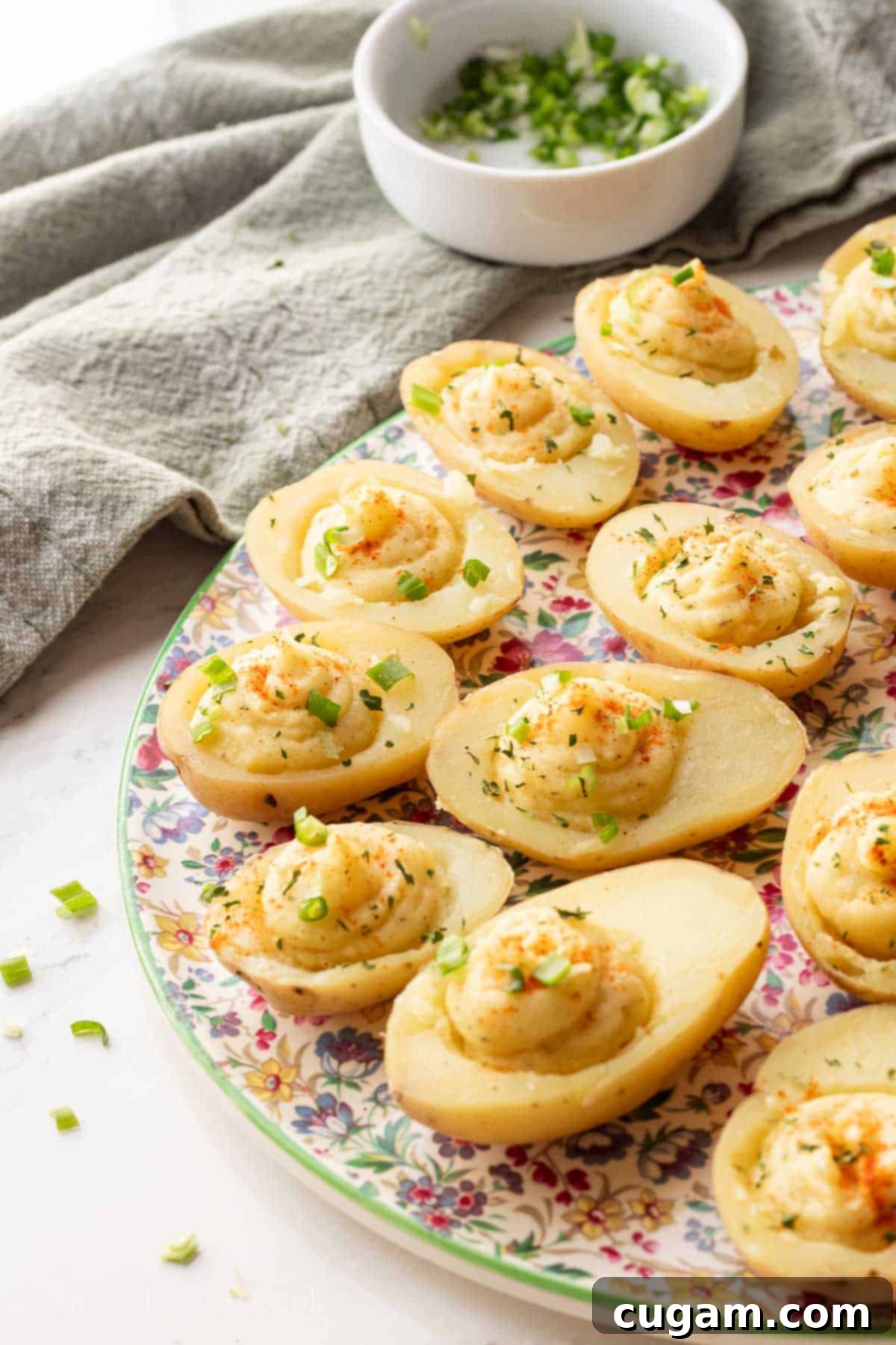 Filled deviled potatoes on a floral plate.