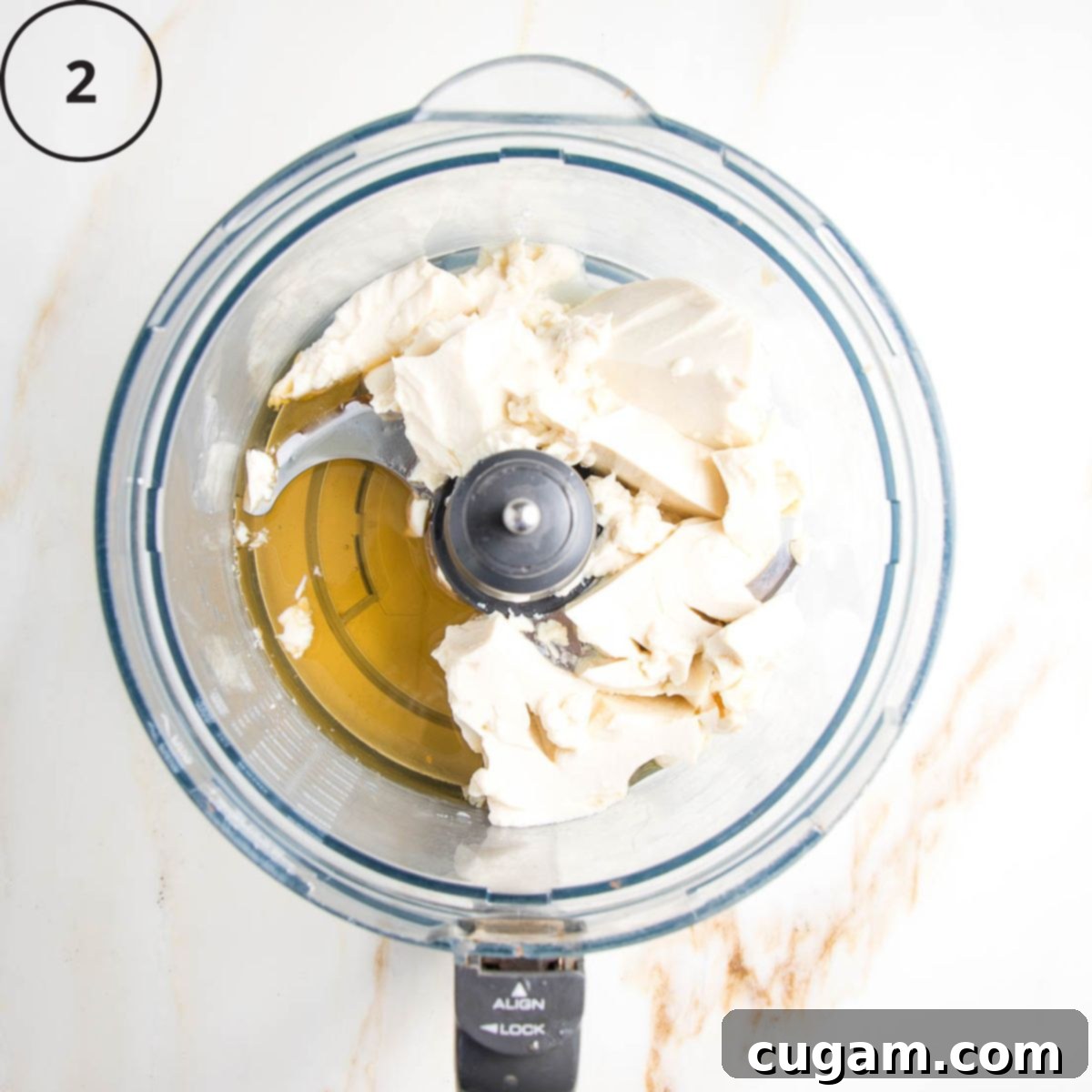 Drained silken tofu and maple syrup in the bowl of a food processor.