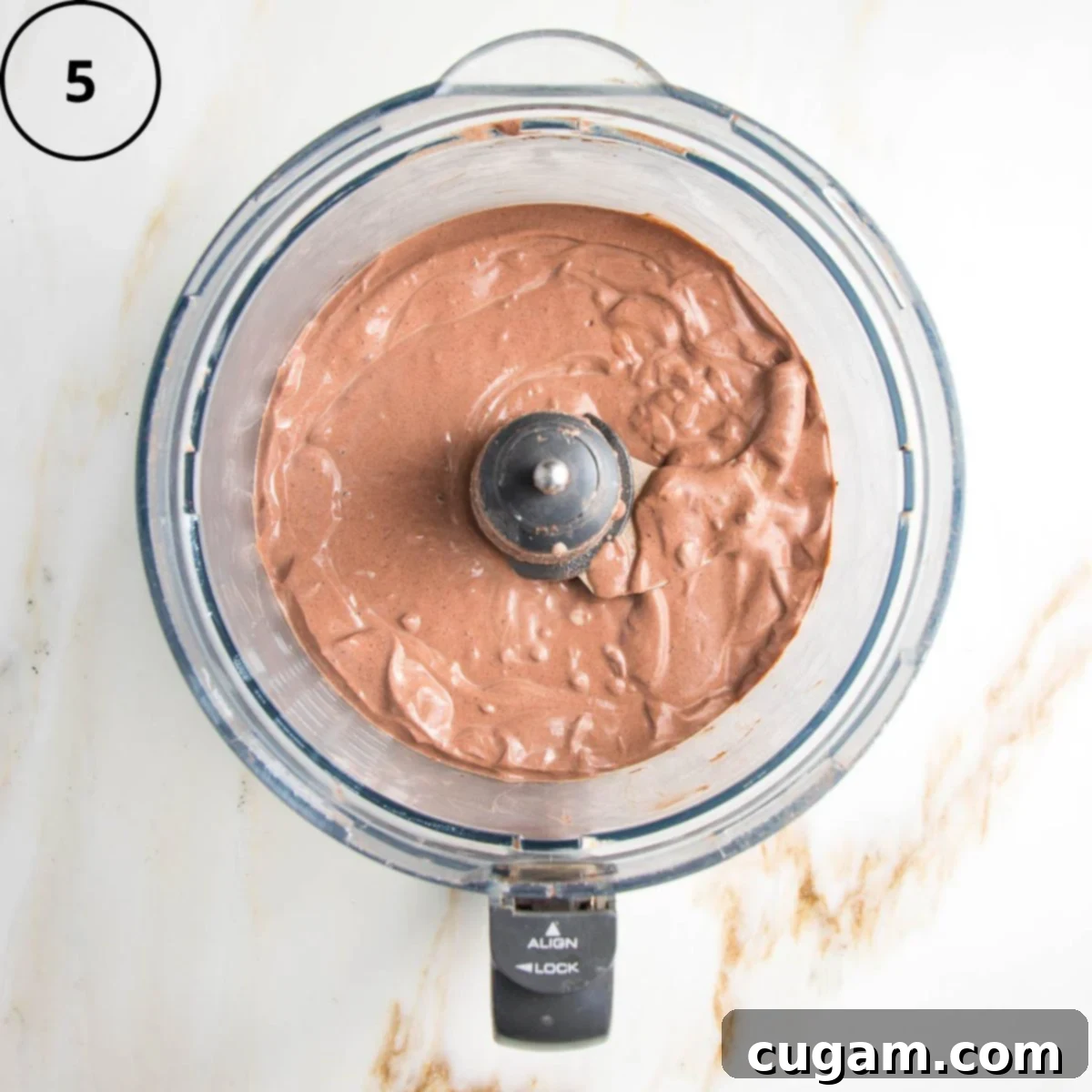 Creamy chocolate pudding in the bowl of a food processor.