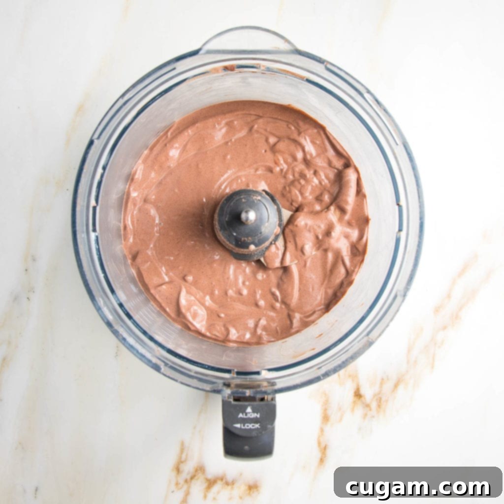 Rich, dark chocolate mousse in the bowl of a food processor. 