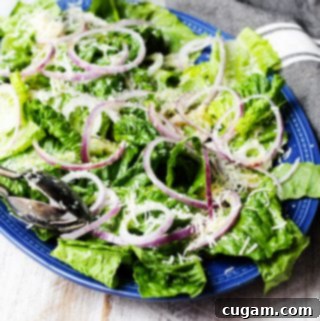 Simple green salad on serving blue plate with kitchen towel on a side