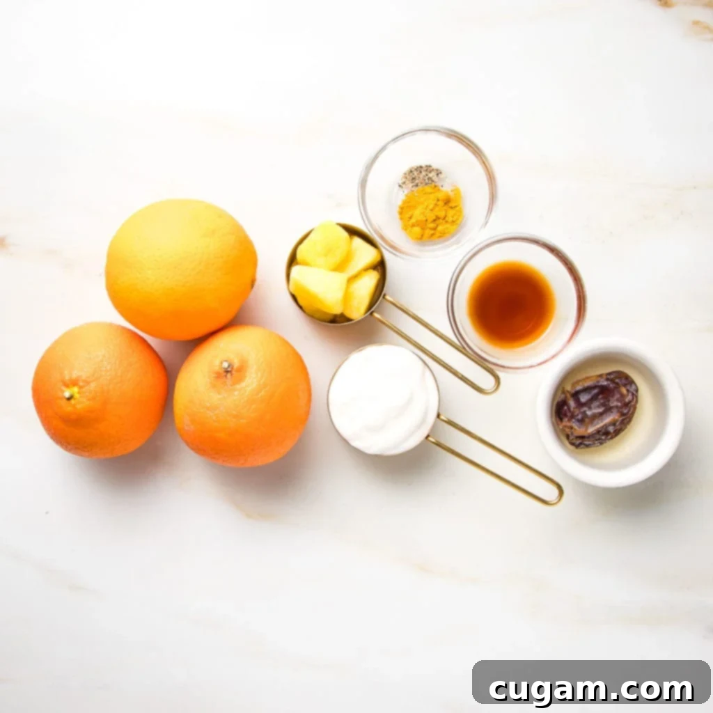 Creamy Orange Bliss 4 A flat lay of ingredients for an Orange Julius smoothie, including fresh oranges, frozen pineapple chunks, a container of plant-based yogurt, a Medjool date, a vanilla bean, and a small pile of turmeric powder with black pepper.