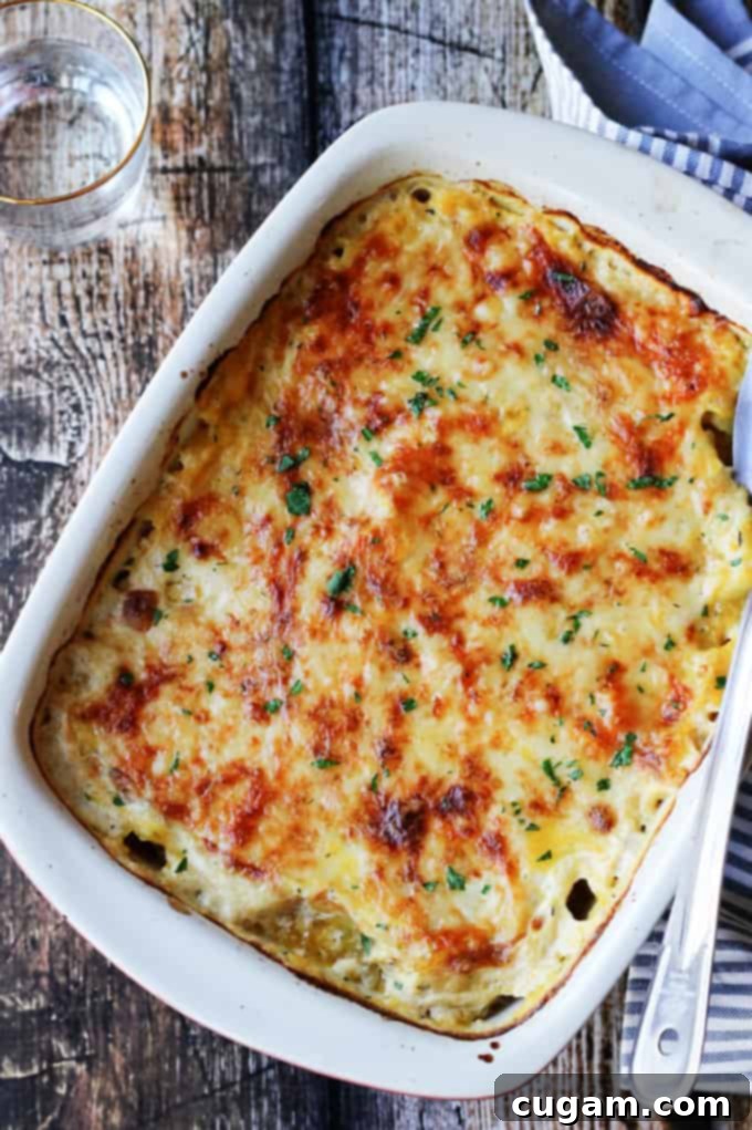 Acorn and Butternut Squash Gratin Casserole in a baking dish with glass of water