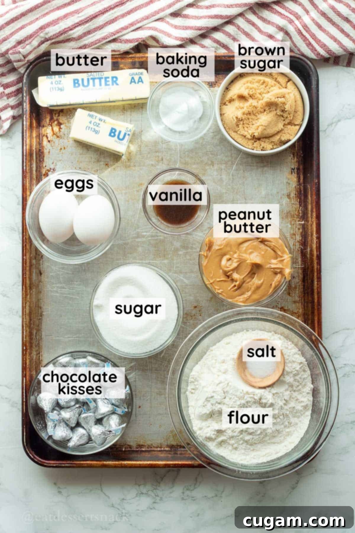 Labeled ingredients for peanut butter kiss bars in glass bowls.