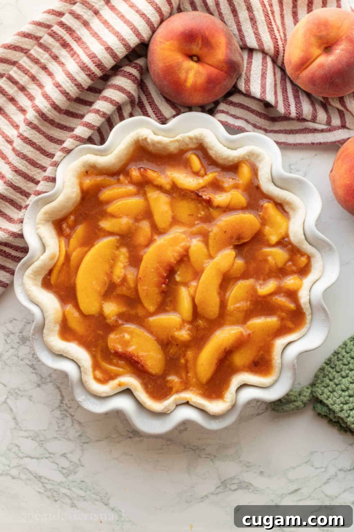 Peach pie filling in pie crust, ready for baking.