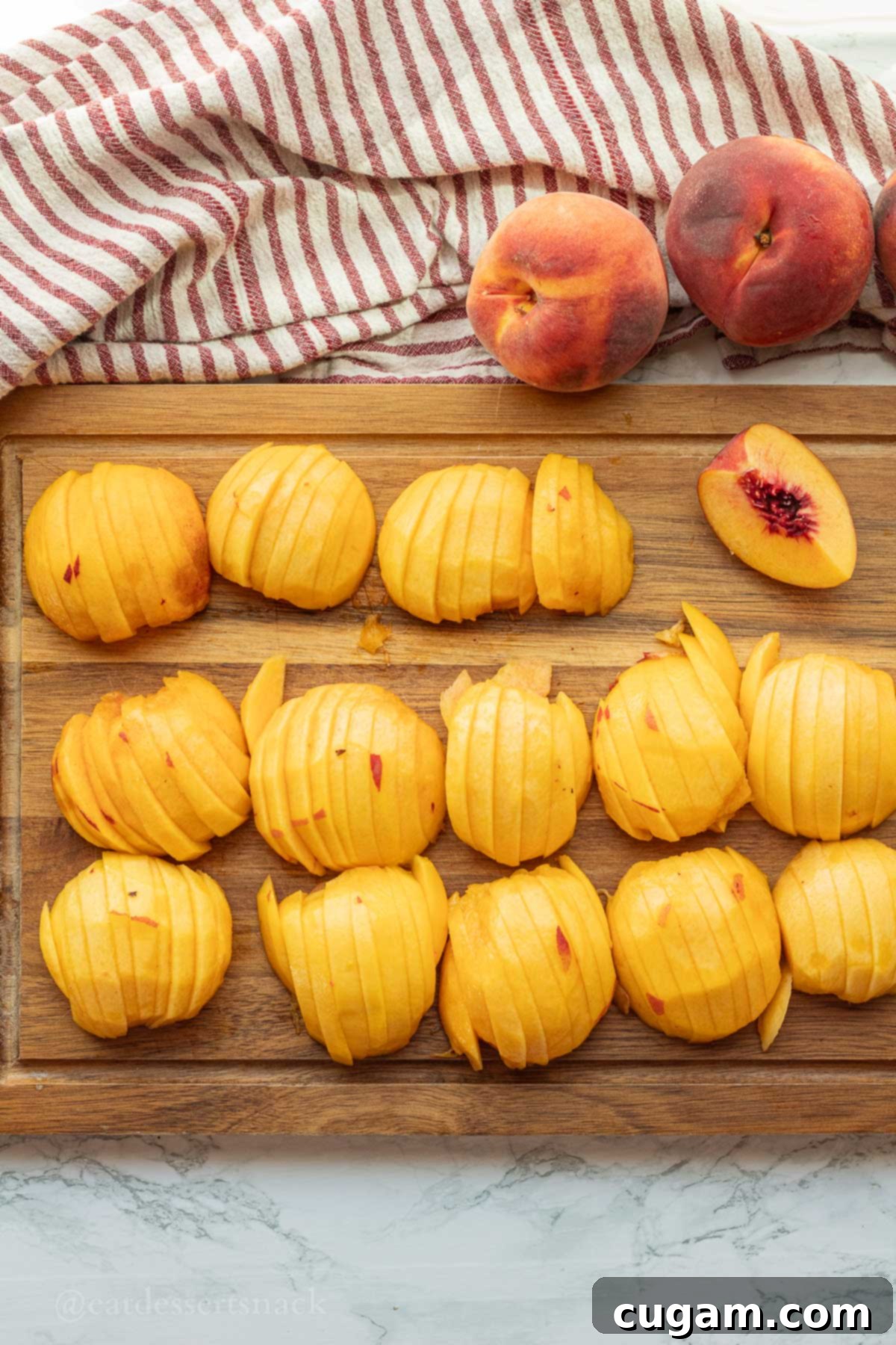 Perfectly sliced raw peaches on a cutting board, ready for the pot.