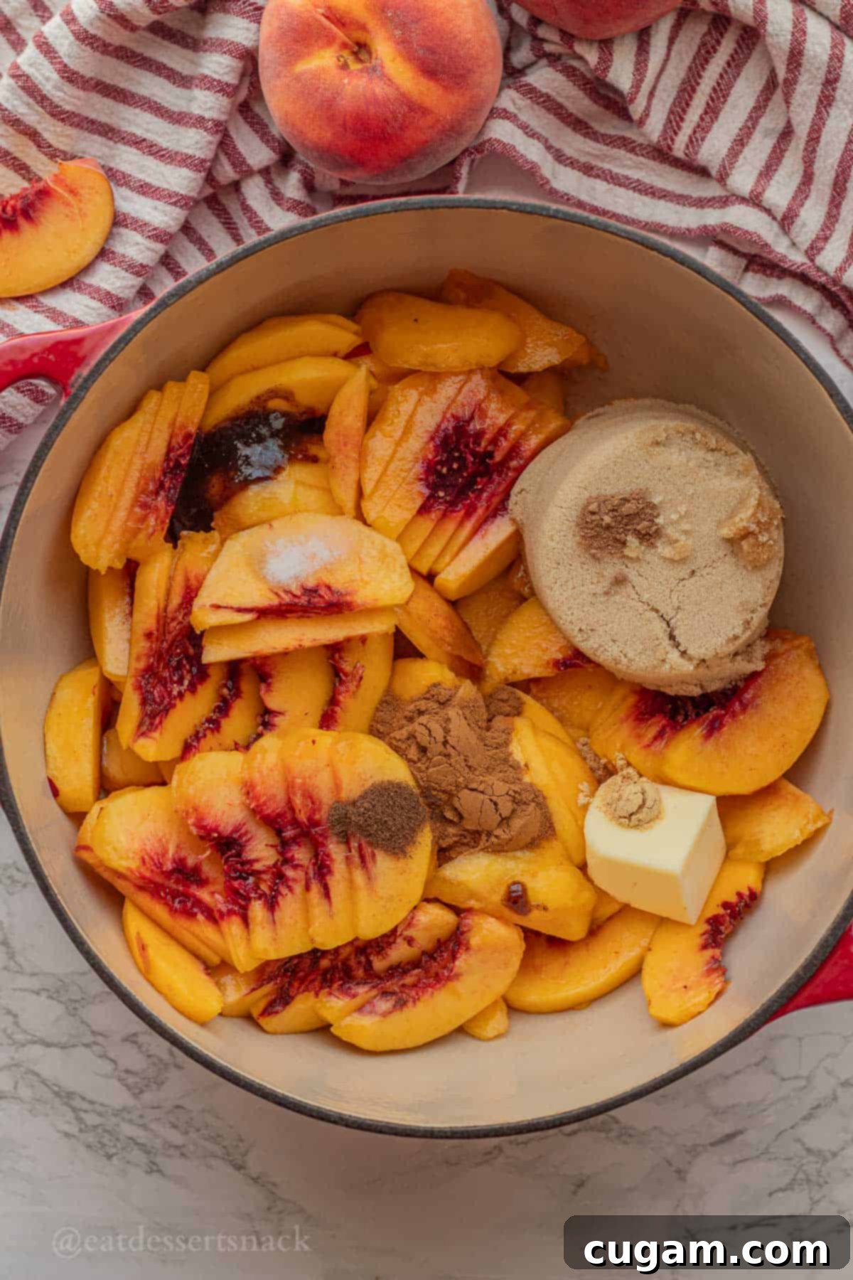 Raw peach pie filling ingredients, including sliced peaches, brown sugar, and spices, combined in a red pot before cooking.
