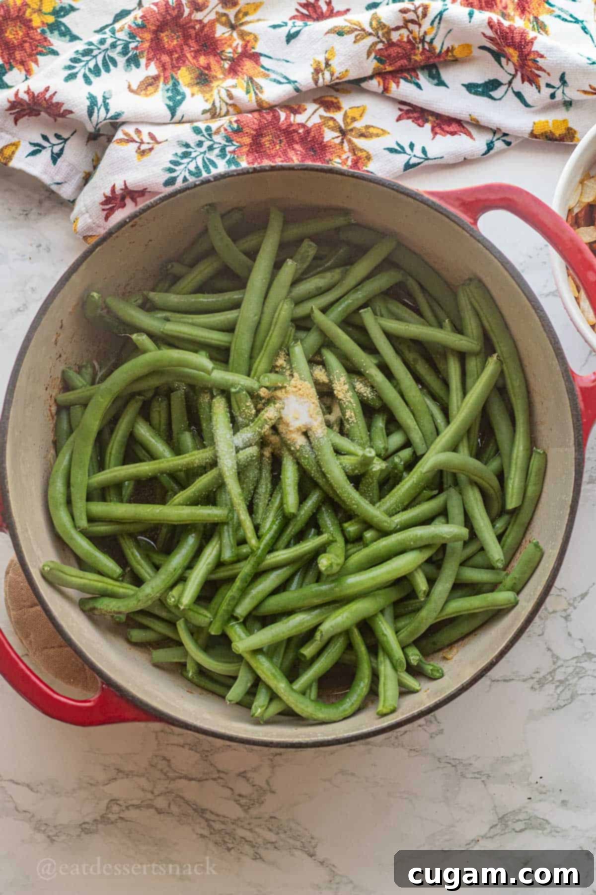 Raw green beans with spices and broth in pan.