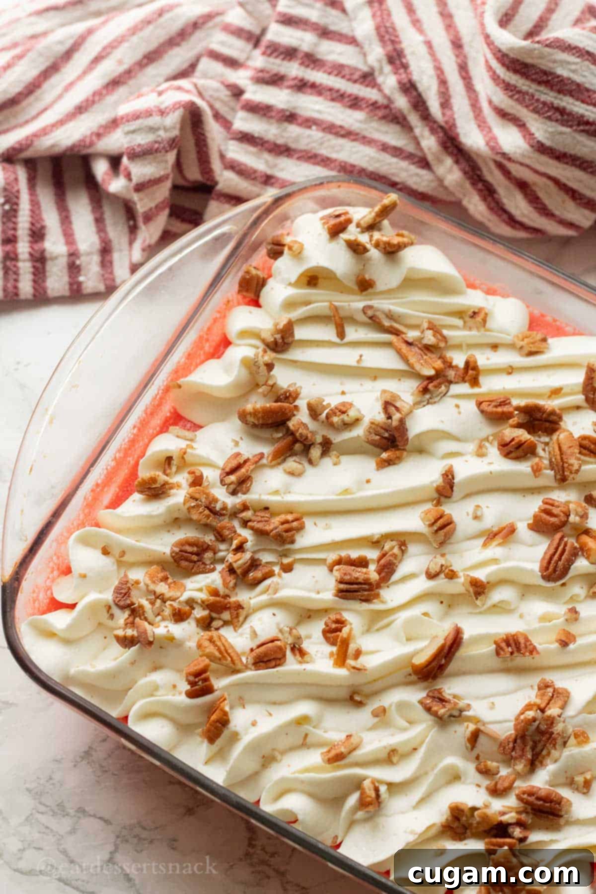 Set cranberry jello salad in a glass pan, topped with elegant piped dollops of whipped cream and generously sprinkled with chopped pecans.