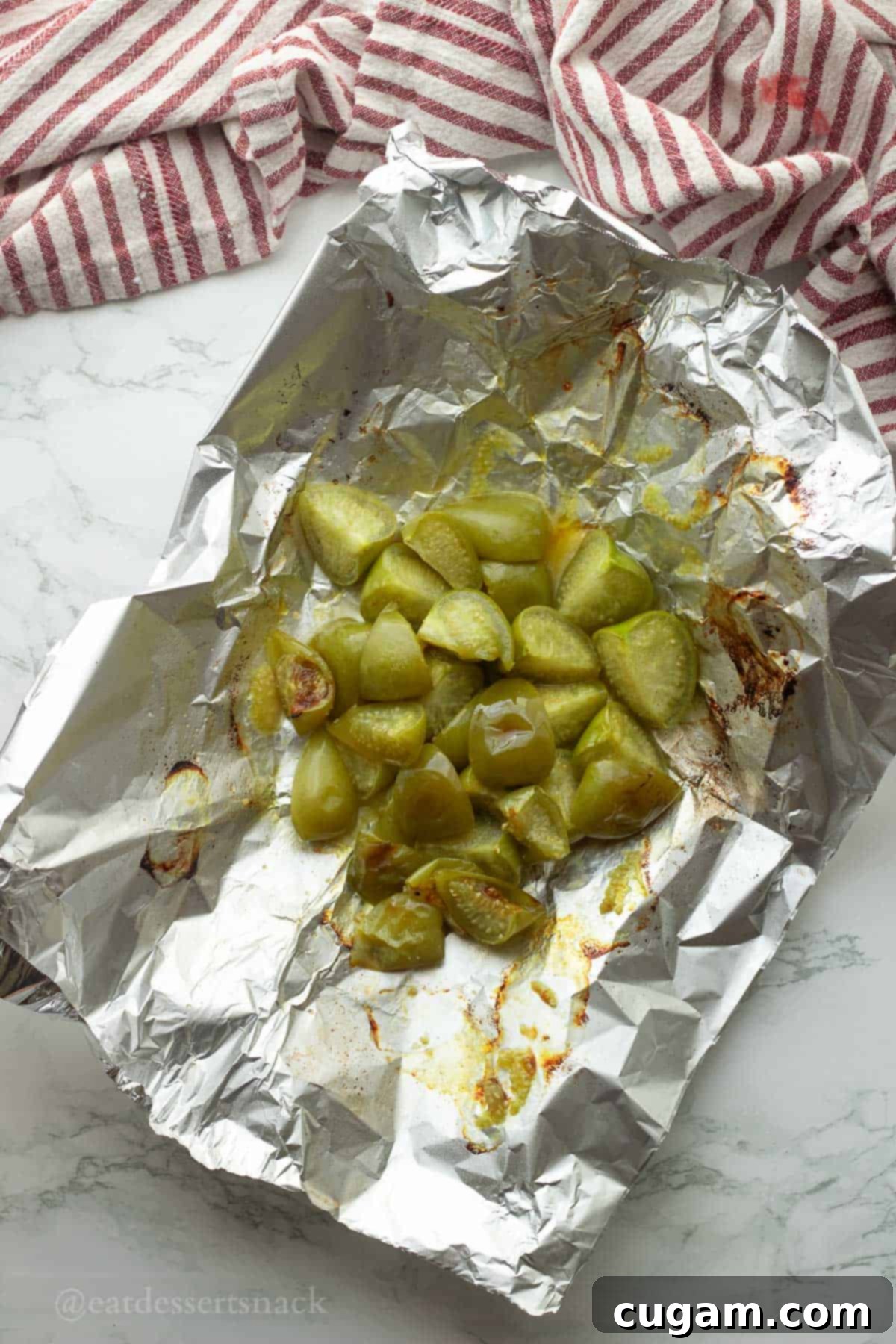 Green Chile Chicken Stew 4 Roasted tomatillos spread on tin foil, baking.