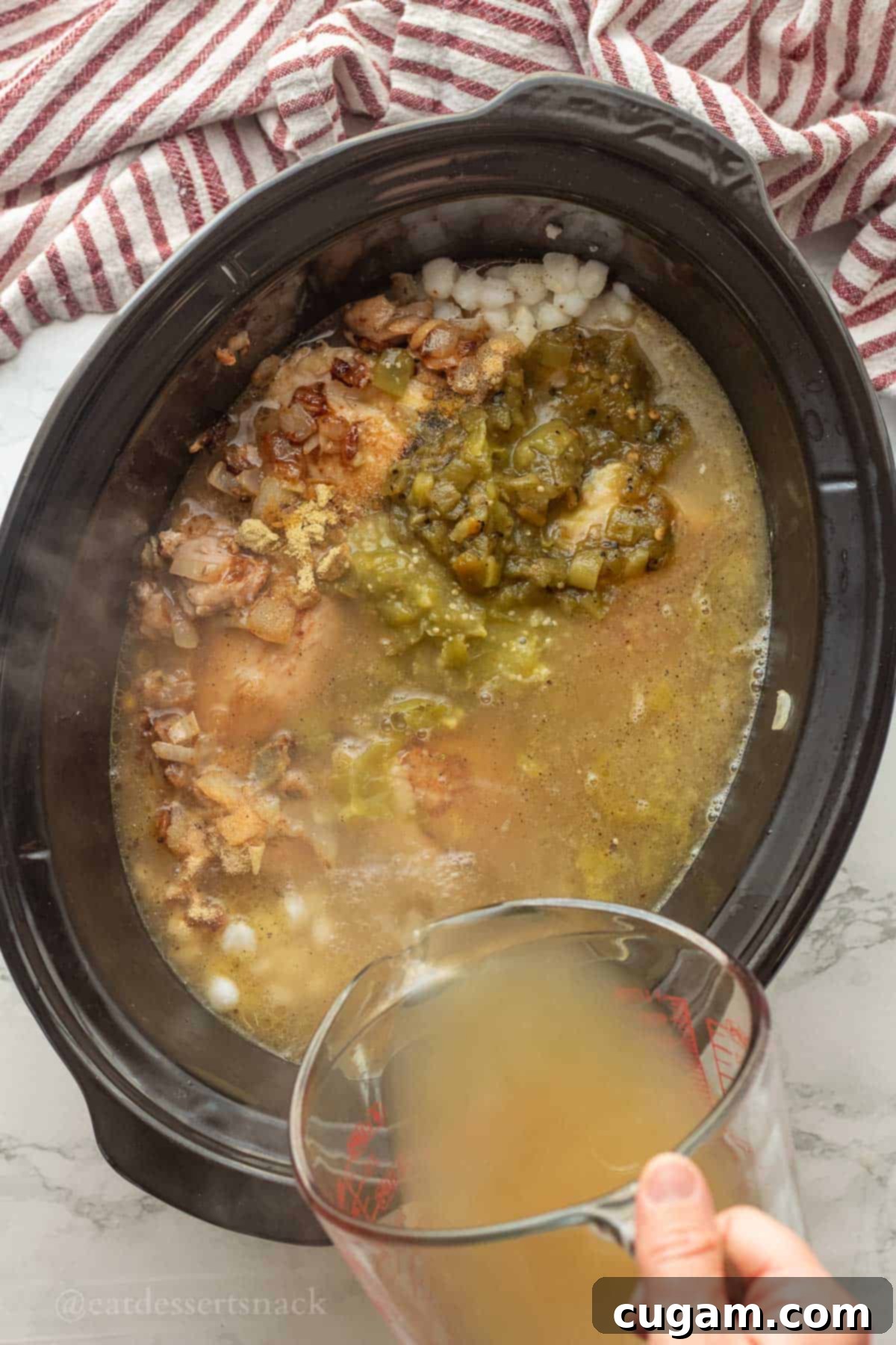 Green Chile Chicken Stew 7 Pouring chicken broth into crockpot with chicken.