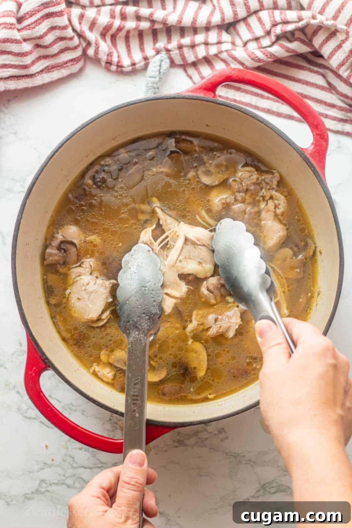 Tom Kha Gai 6 Shredding cooked chicken with tongs.