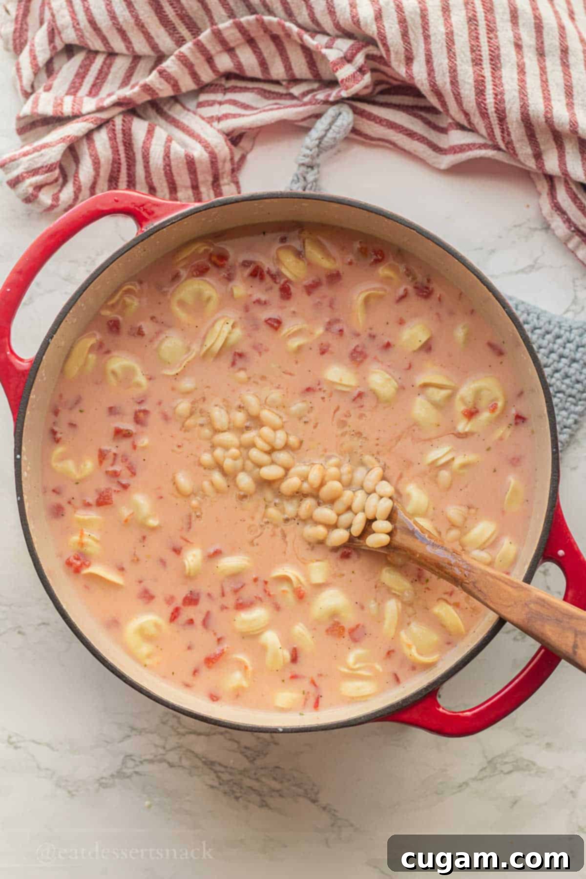 Tomato, White Bean & Tortellini Soup: A Tuscan Twist 6 White beans in soup pot with wooden spoon.
