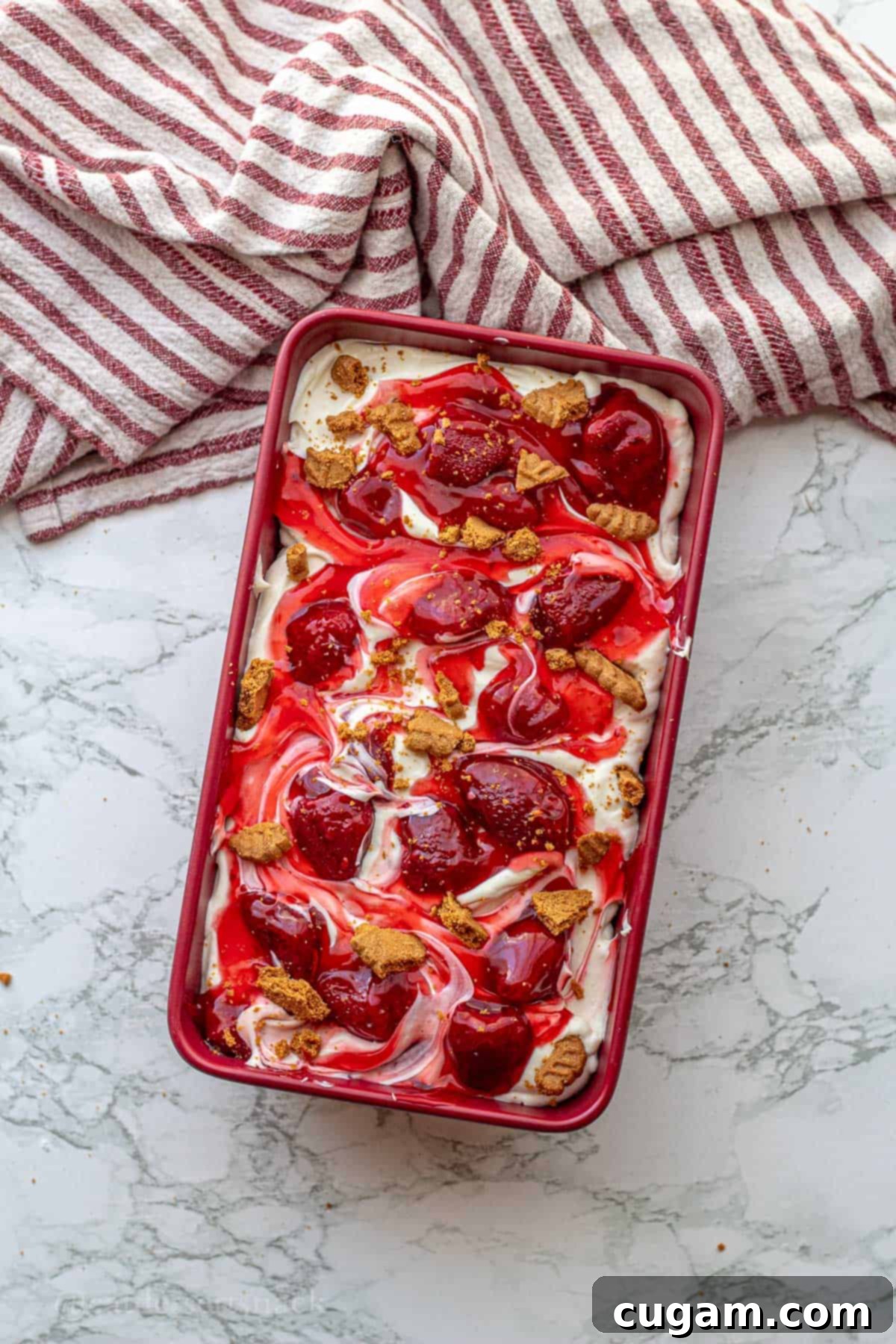 Strawberry Cheesecake Ice Cream (Easy Homemade Recipe) 2 Strawberry cheesecake ice cream in a pan with biscoff crumbles on top.