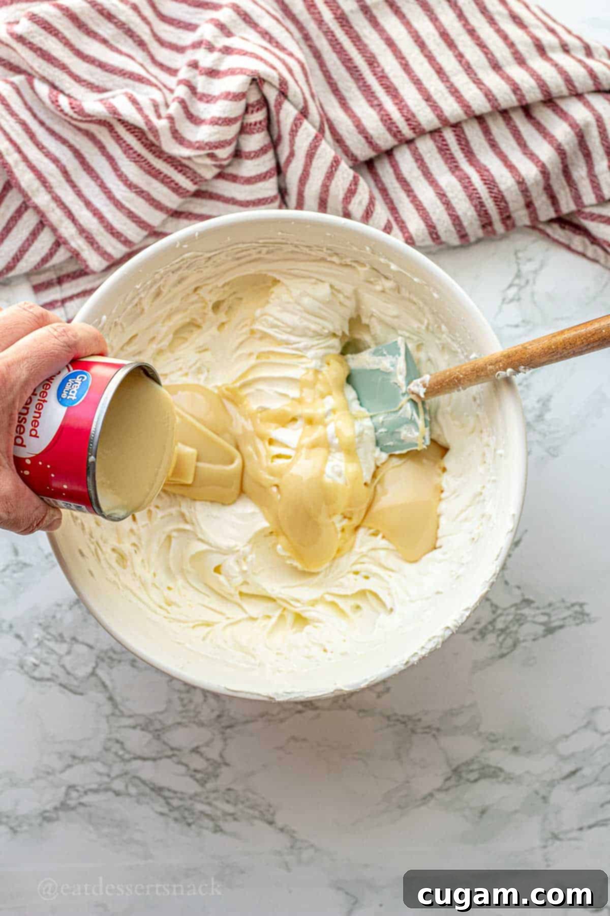 Strawberry Cheesecake Ice Cream (Easy Homemade Recipe) 6 Pouring sweetened condensed milk into bowl of whipped cream.