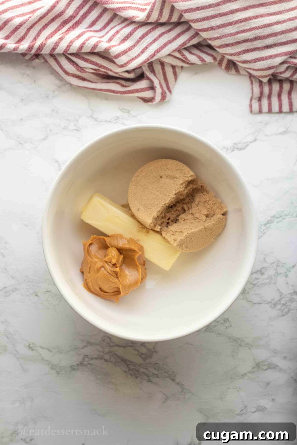 Chocolate Chip Peanut Butter Swirl Cookies 4 A close-up shot of brown sugar, peanut butter, and softened butter being creamed together in a mixing bowl.