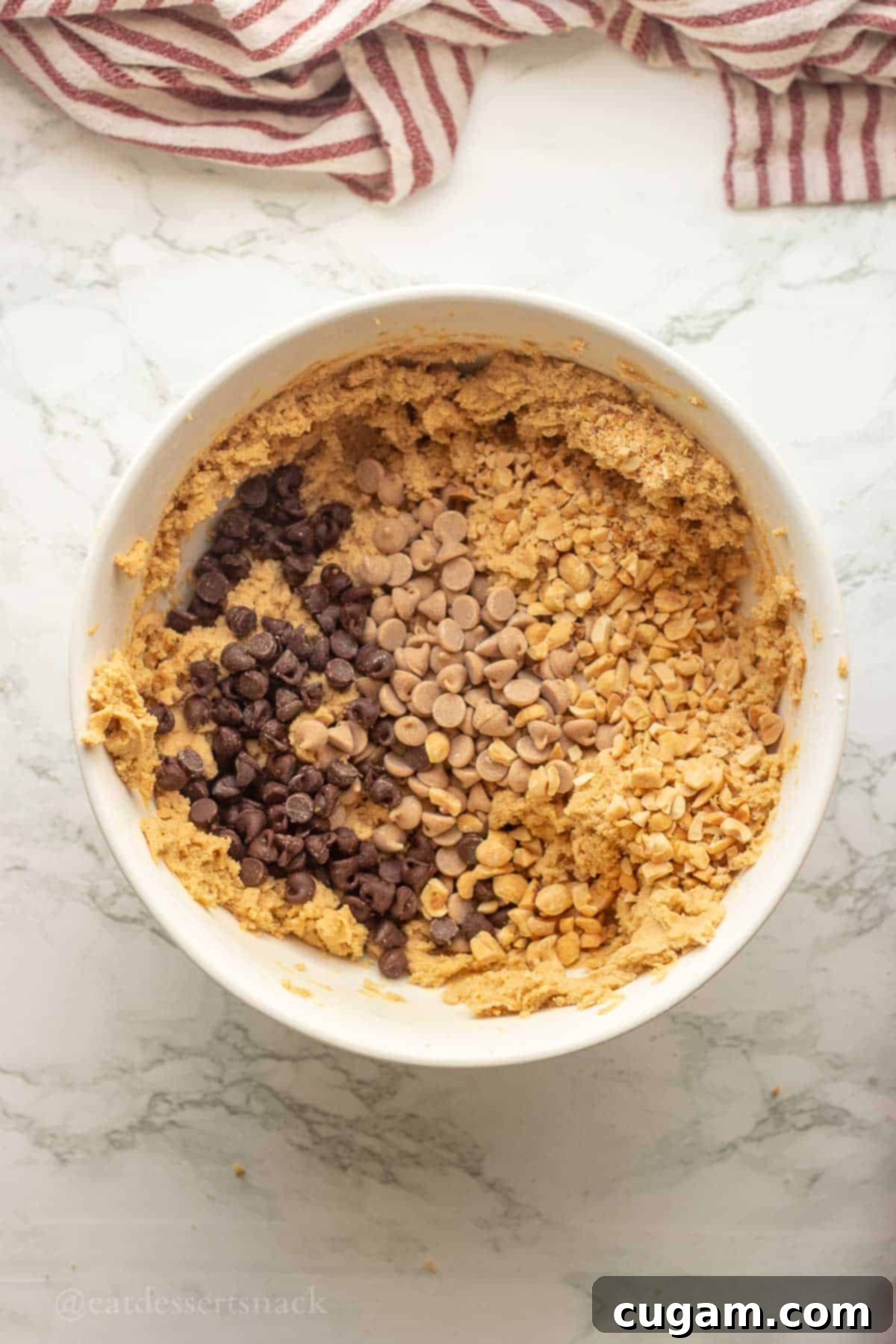 Chocolate Chip Peanut Butter Swirl Cookies 7 Baking chips being mixed into the bowl of cookie dough, adding bursts of chocolate and peanut butter flavor.
