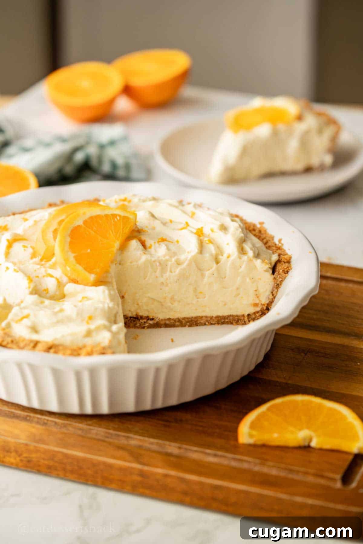 Sunshine Citrus Dream Pie 9 Slice removed from orange pie in pan.
